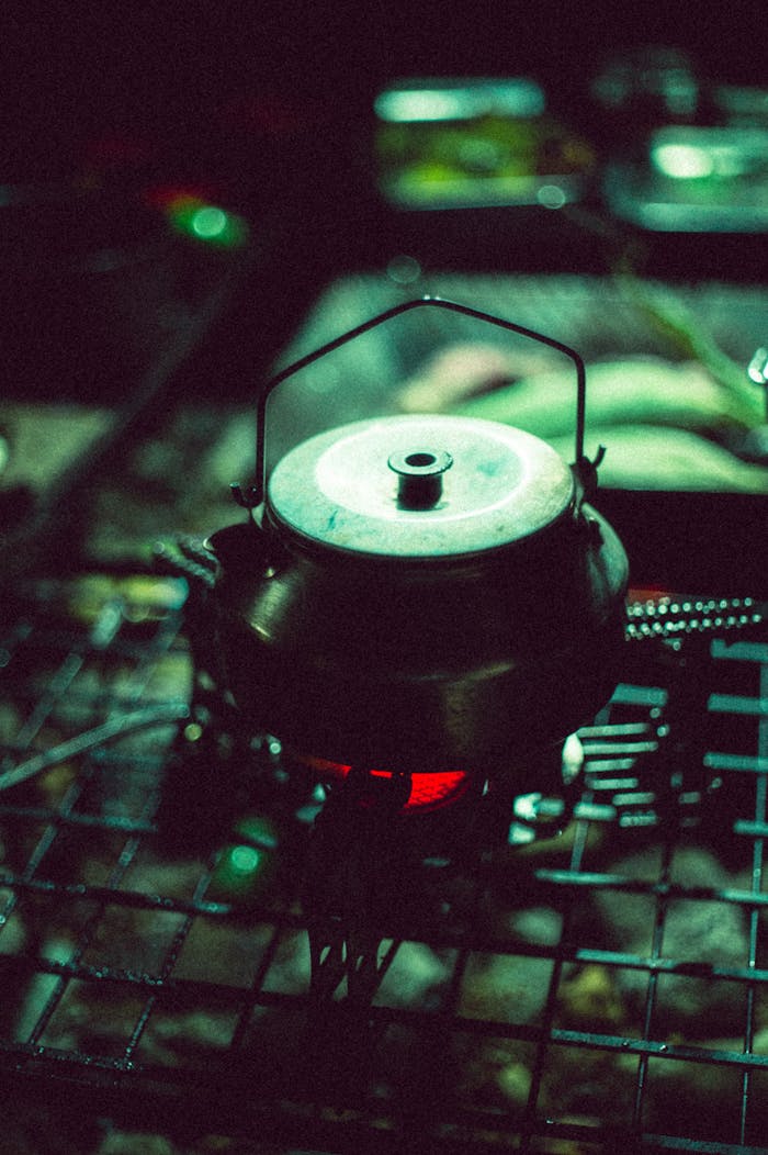 Vintage kettle heating on a gas stove, creating a cozy atmosphere in a dimly lit kitchen setting.