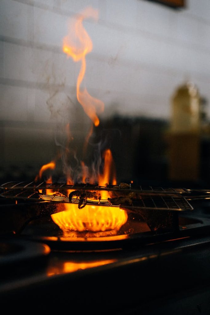 pexels-photo-6937450 Close-up of a fiery stove with intense flames, showcasing cooking ambiance.